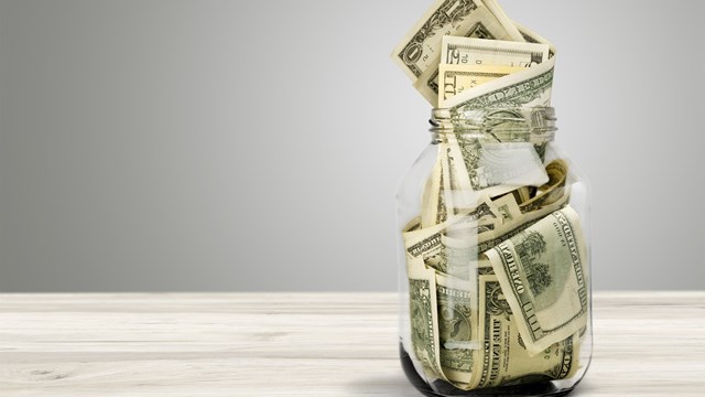 Glass jar for money on background