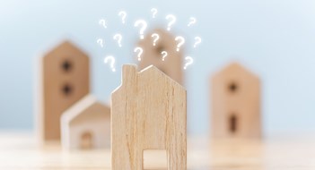 Boards, Managers, Landlords Real estate developer and managing property investment concept. Selective focus wooden houses with question mark on table