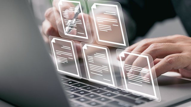 Businessman working on laptop computer with electronics document icons, E-document management, online documentation database, paperless office concept