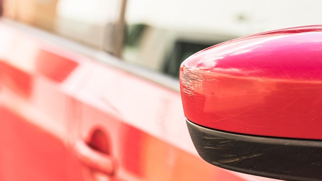 Close-up of rear view mirror with scratches.