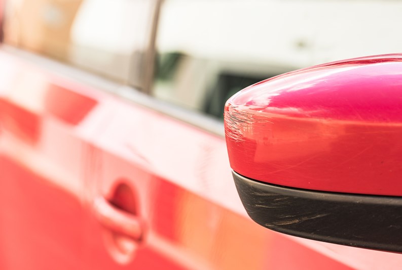 Close-up of rear view mirror with scratches.