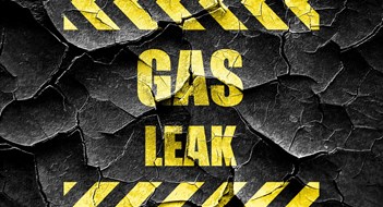 NYC’s Gas Detector Law - Understanding Local Law 157 'GAS LEAK' warning sign in yellow block lettering on cracked black background