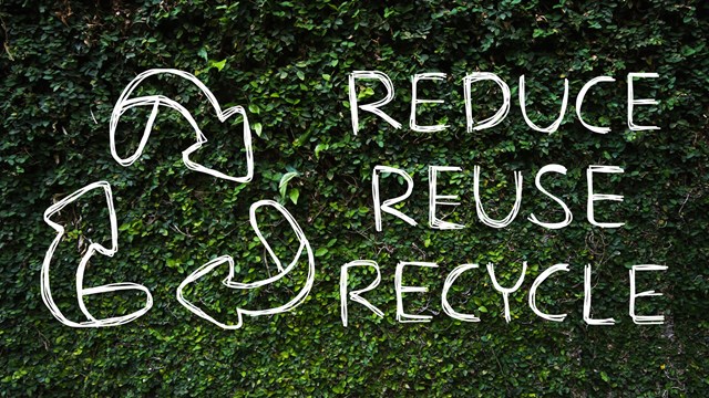Hand drawing Reduce - Reuse - Recycle symbol with green nature background.