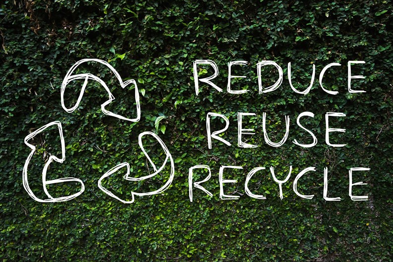 Hand drawing Reduce - Reuse - Recycle symbol with green nature background.