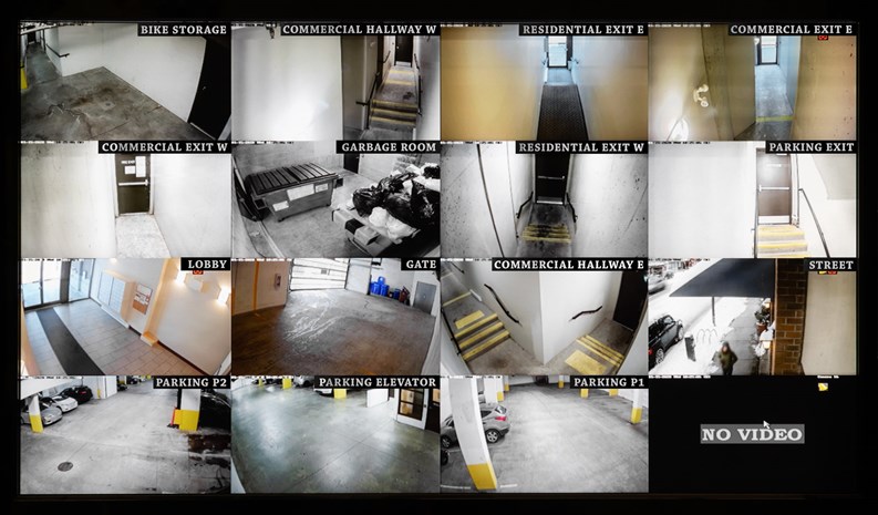 Screen showing security camera views of parking, gate, garbage and recycling room, staircase and hallway.