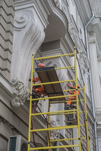 Workers restore the facade of an old building