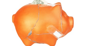 Financial, Physical, & Operational Health cracked and bandaged piggy bank with one dollar bill inside it