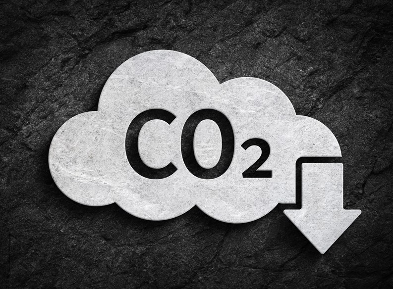 Cloud and co2 symbol with down arrow for greenhouse gas pollution reduction symbol on dark stone wall background