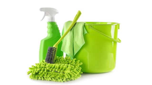Plastic bucket with different cleaning supplies isolated on white