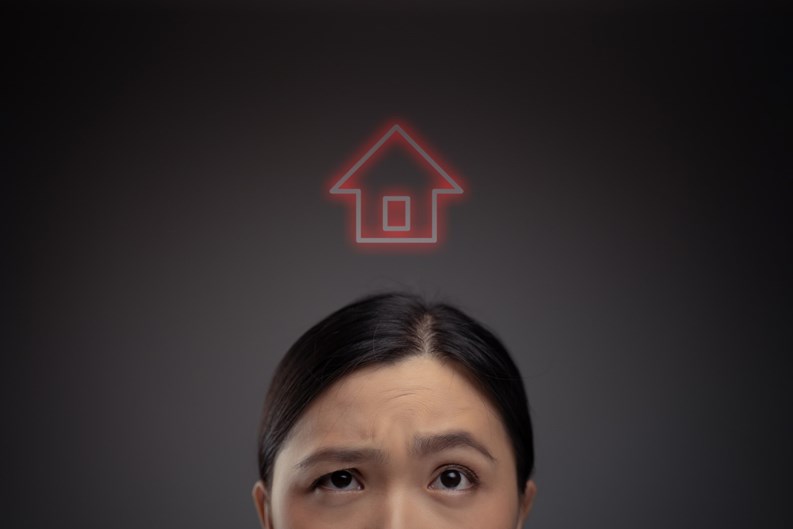 Unhappy Asian woman and home icon hologram effect. Isolated on background.