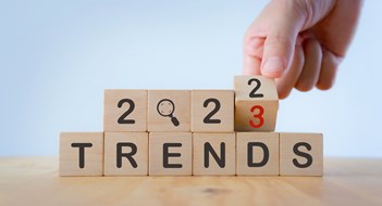 Market Wrap-Up 2022 2023 trend concept. Hand flip wooden cube change year 2022 to 2023. Beautiful white background, copy space. Used for the banner trend concept of the new year for monitoring new business opportunities.