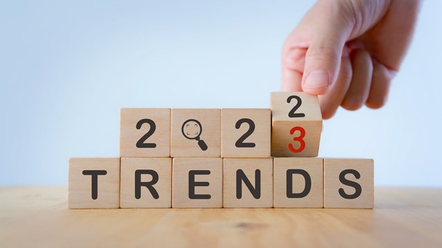 2023 trend concept. Hand flip wooden cube change year 2022 to 2023. Beautiful white background, copy space. Used for the banner trend concept of the new year for monitoring new business opportunities.