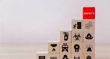 Safety Inspections A graduated stack of wooden blocks showing different safety-related icons with a red block reading SAFETY at the top