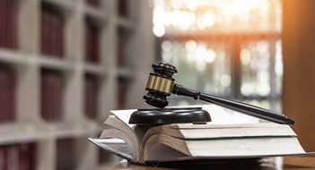 Laws vs. Bylaws Law, legal judgement, legistration, litigation, court verdict, judicial system and civil right and social justice concept with judge gavel on law textbook in attorney law firm, lawyer business office