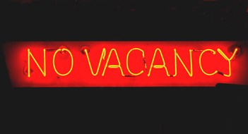 Short-Term Rental Registration Law Curbs Airbnb Red neon sign of "No Vacancy" at night