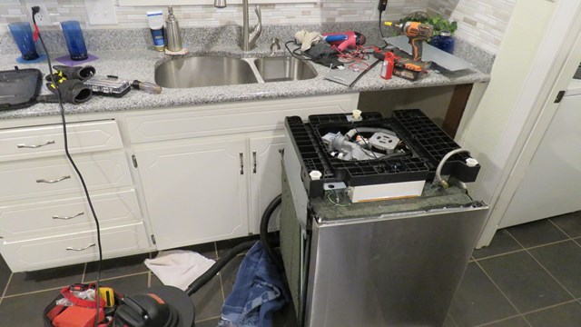 kitchen dishwasher being repaired