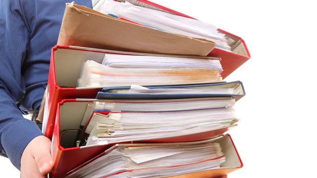 Man holding stack of folders. Pile with old documents and bills. Isolated on white background
