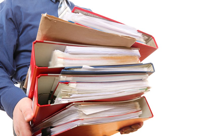 Man holding stack of folders. Pile with old documents and bills. Isolated on white background