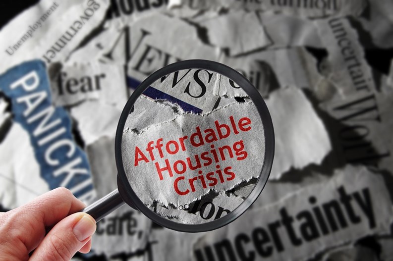 Affordable Housing Crisis newspaper headline and magnifying glass