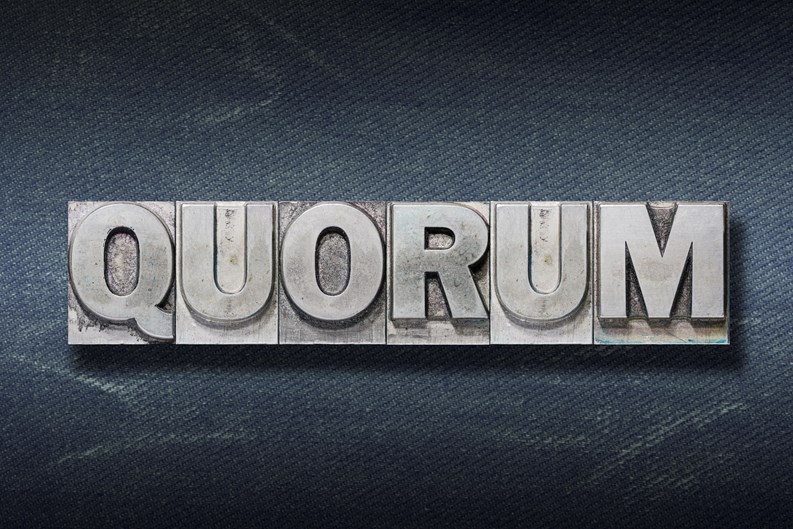 quorum word made from metallic letterpress on dark jeans background"r"n