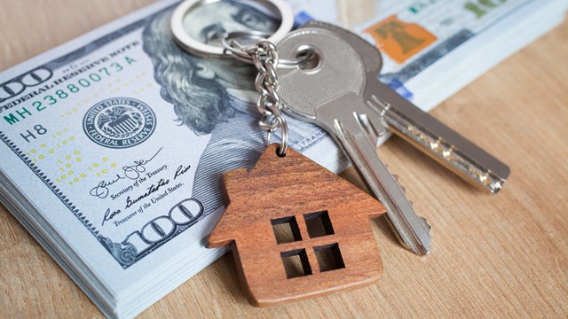 Real estate investing concept. American dollar, cash or housing. Keys close-up
