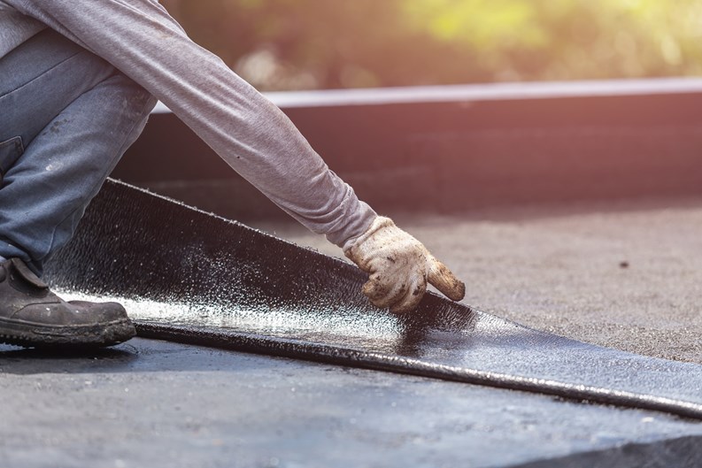 Asia worker installing tar foil on the rooftop of building. Waterproof system by gas and fire torching