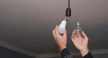 New Environmental Rules Coming This Year for Co-op & Condo Buildings The concept of energy saving. incandescent lamp and energy-efficient LED lamp in your hands.