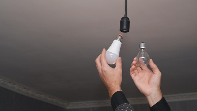 The concept of energy saving. incandescent lamp and energy-efficient LED lamp in your hands.