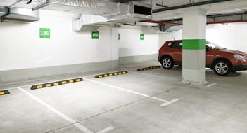New Regulations Prop Up Garage Inspection & Repair Requirements Underground car parking, empty modern parking lot indoor. Inside light parking garage in mall basement.