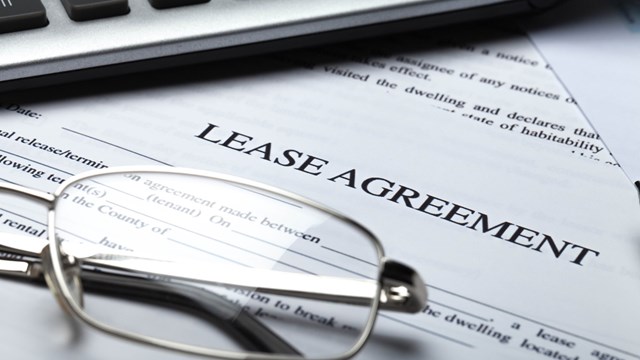 Lease Agreement Documents with Glasses, Pen and Calculator