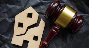 Q&A: Tenant Obligations During Foreclosure Divided house and wooden gavel. Division of real estate in case of divorce or inheritance.