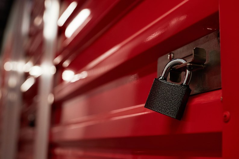 Padlock on closed red metal door in warehouse