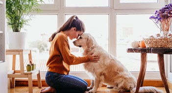 Pet-Friendly Policies beautiful woman hugging her adorable golden retriever dog at home. love for animals concept. lifestyle indoors