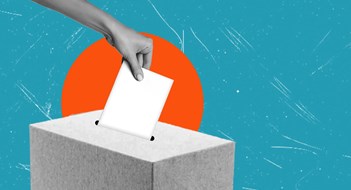 Q&A: Election Rules A hand is placing a blank ballot into a gray voting box, with a colorful blue backdrop featuring a sunburst, representing participation in democratic processes.