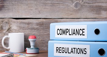 Compliance & Recordkeeping Compliance and Regulations. Two binders on desk in the office. Business background