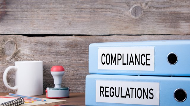 Compliance and Regulations. Two binders on desk in the office. Business background