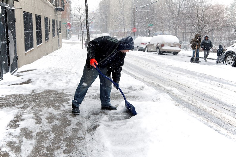 Bronx, NY, USA - JANUARY 19, 2014: man shoveling during snow storm .